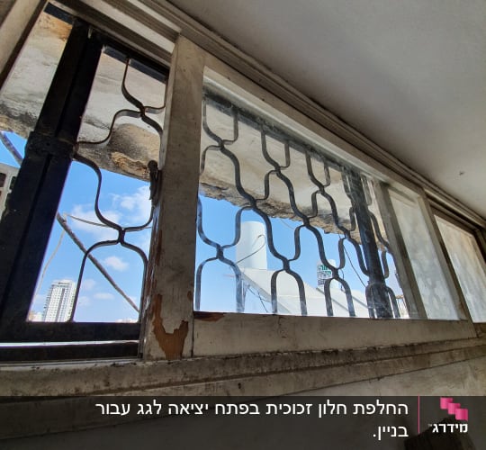 חלון זכוכית עם סורגי מתכת וחלון פתוח